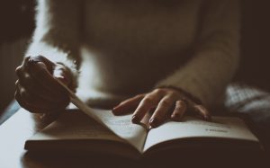 A business student reading a book regarding consumer behavior